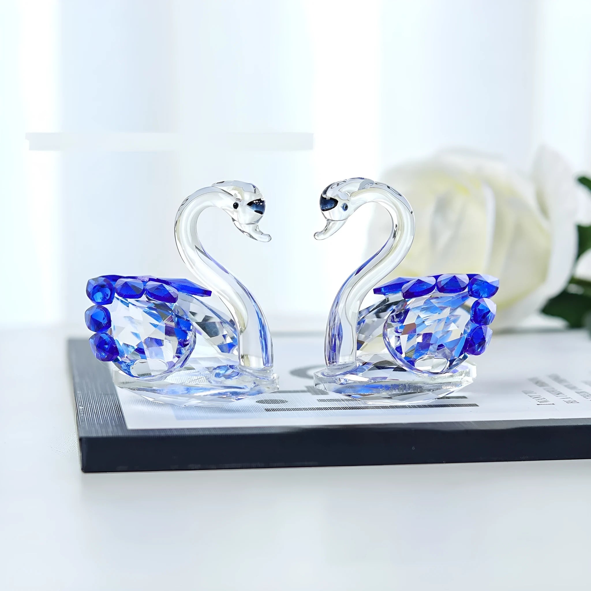 Crystal swan desktop ornament in red, blue, pink, or purple on a wooden surface.