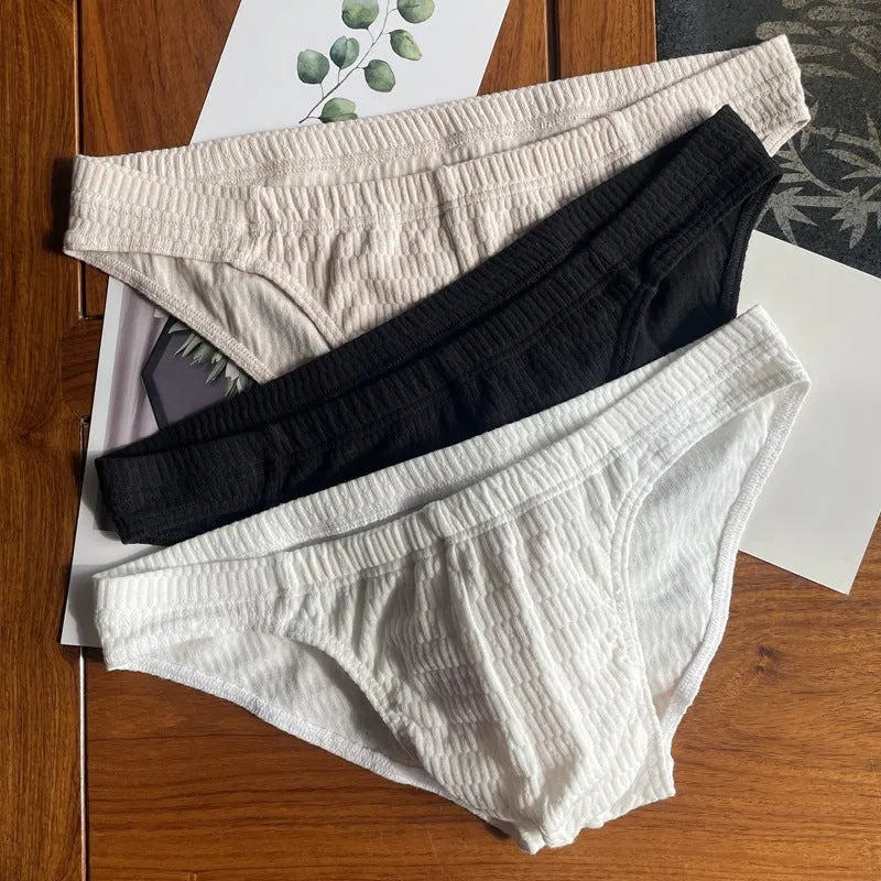 Men's solid colour cotton briefs with mid waist and triangle style in apricot black and skin colour.