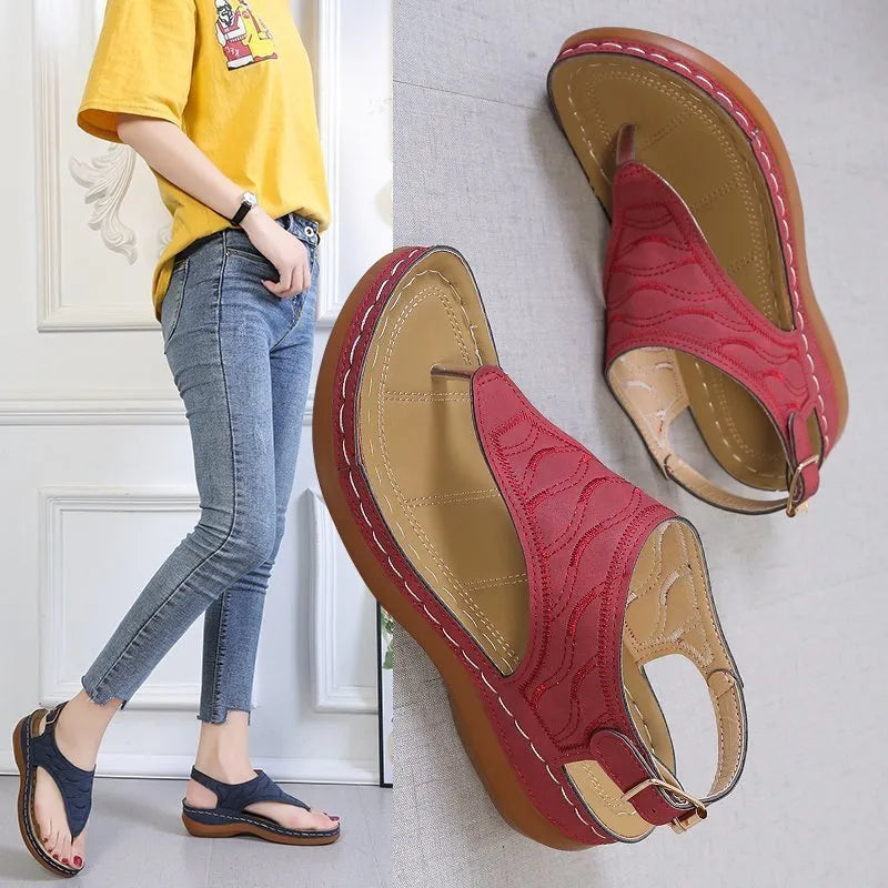 Women's black casual wedge heel flip flop sandals showing adjustable back buckle strap and solid colour design.