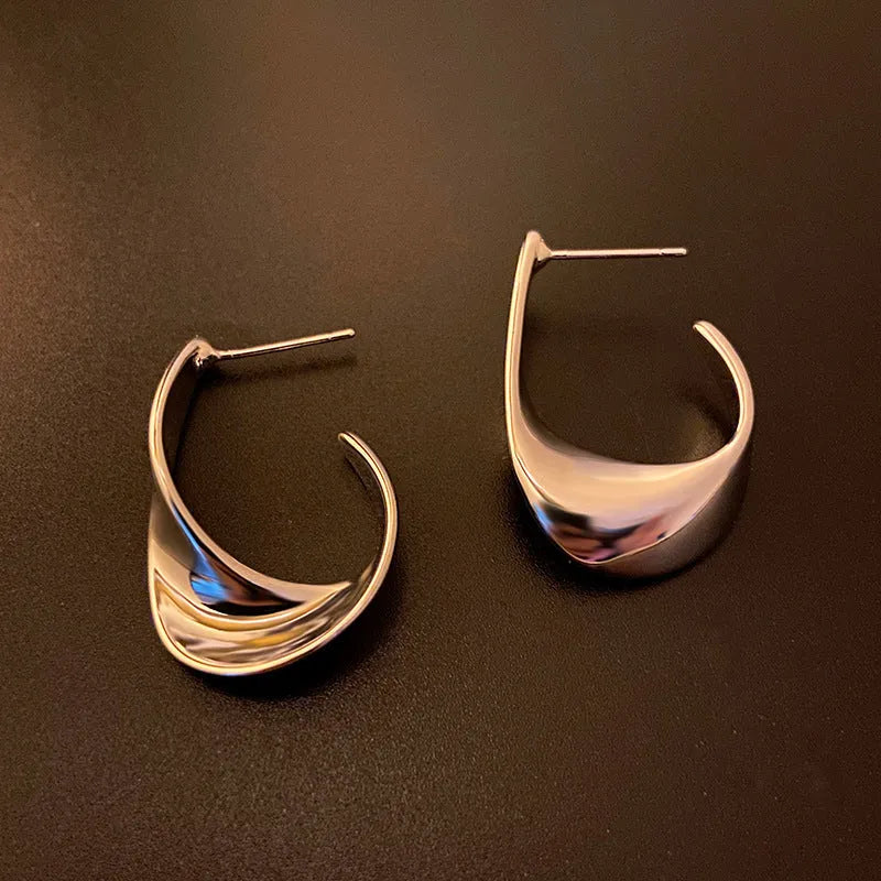 Metal twisted geometry earrings with round element in gold or silver electroplated finish