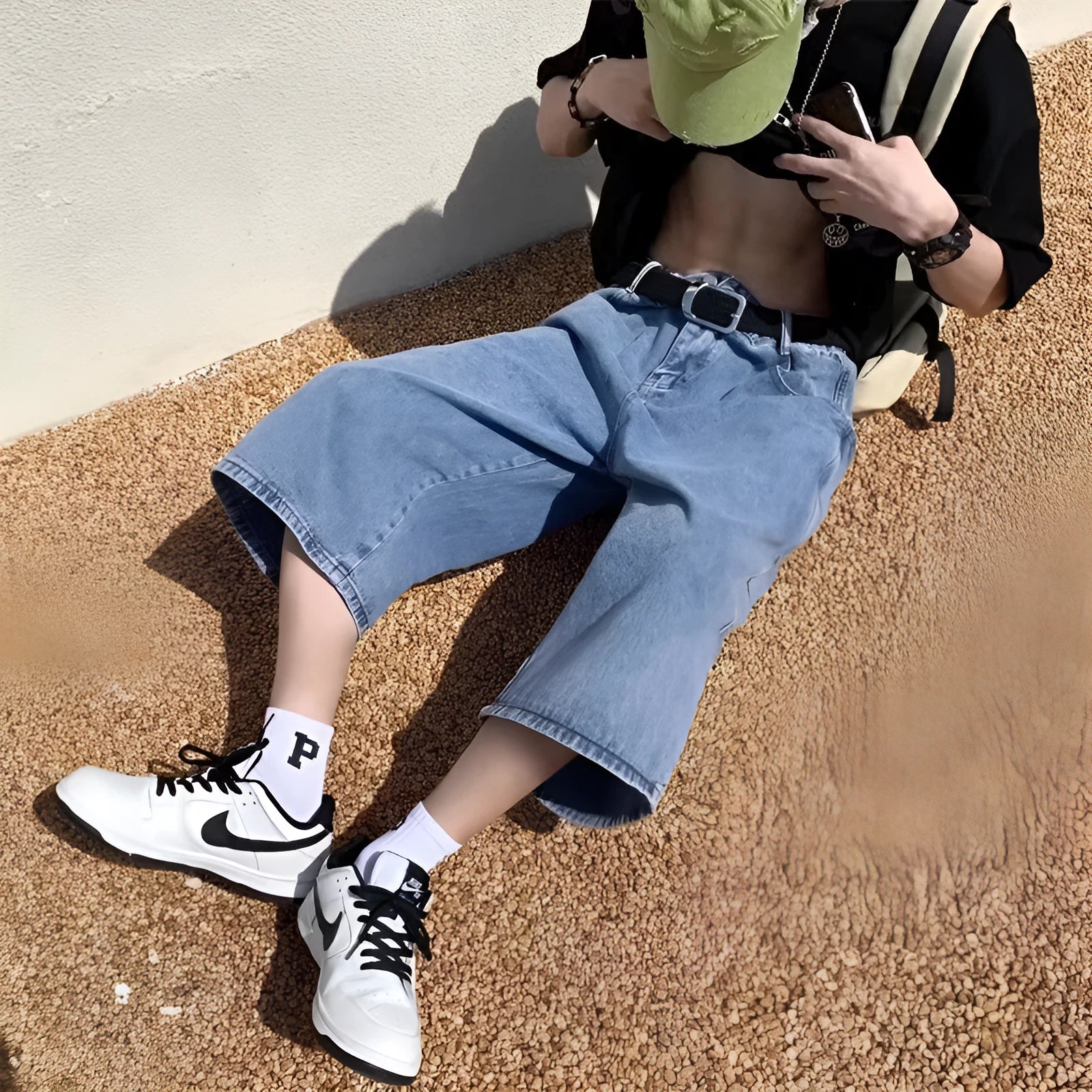 Blue washed denim shorts for men with high waist and cropped pirate-style legs on a plain background.