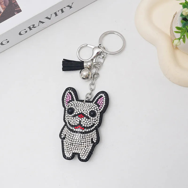 Close-up of a rhinestone dog charm keychain in a caramel colour with sparkling stones on a metal base.