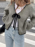 Grey lace-up sweater cardigan with long sleeves, a front crocheted flower, and a loose fit.