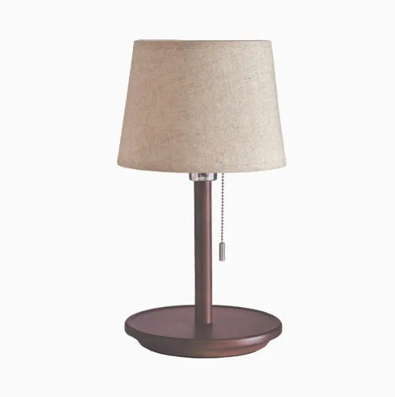 Walnut coloured solid wood desk lamp with a white fabric lampshade and a cable switch.