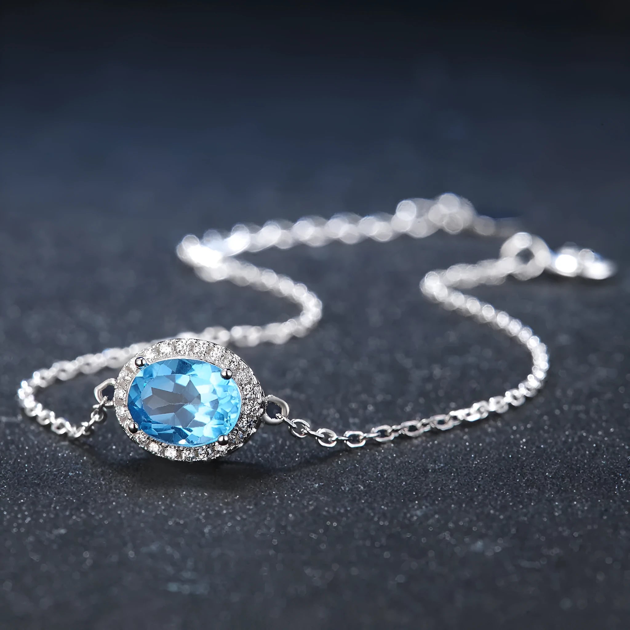Women's 925 sterling silver jewellery set with blue topaz gemstones showing earrings, ring, pendant, and necklace with geometric pattern