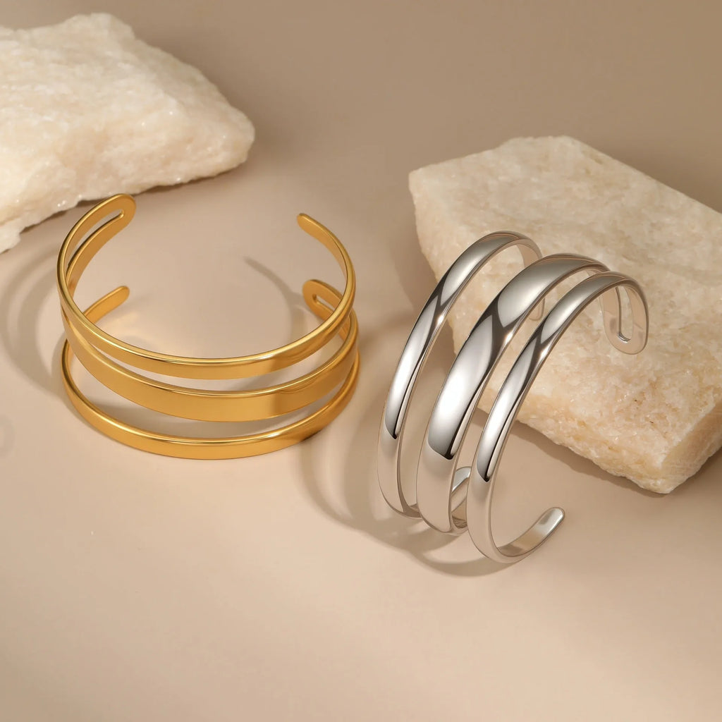 Geometric stainless steel women's bracelet with a simple opening mechanism, shown in gold and steel finish options.