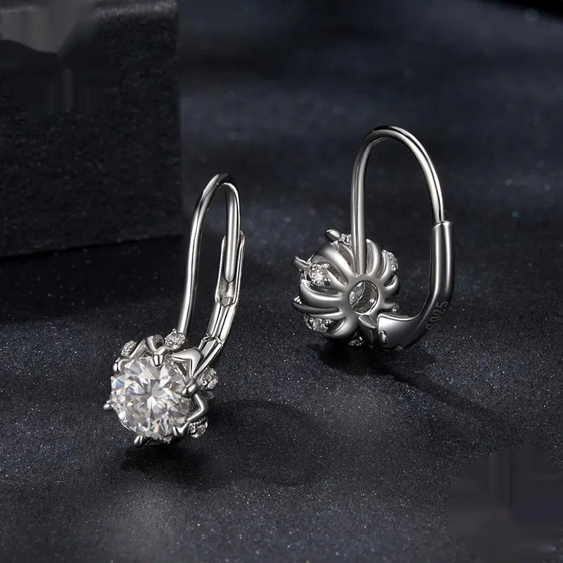 Close-up of a sterling silver flower bud clip earring with a moissanite centre, shown on a white background.