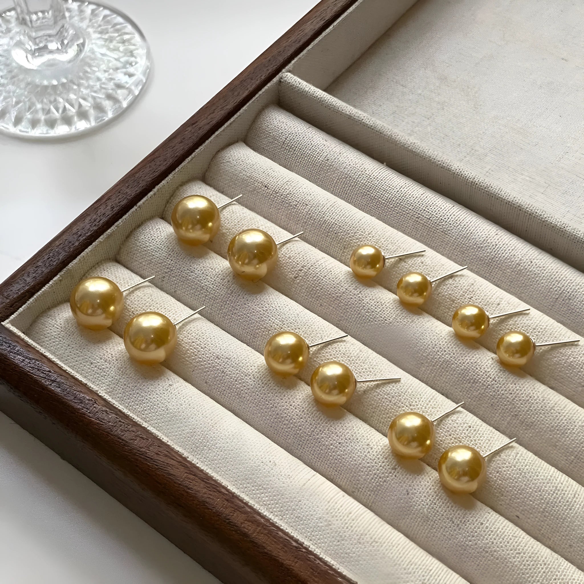 A pair of large geometric pearl stud earrings for women in silver, showing an eight-point star design detail.
