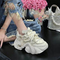 Women's casual wedge sneaker in synthetic leather with cross-strap detail and a thick platform sole.