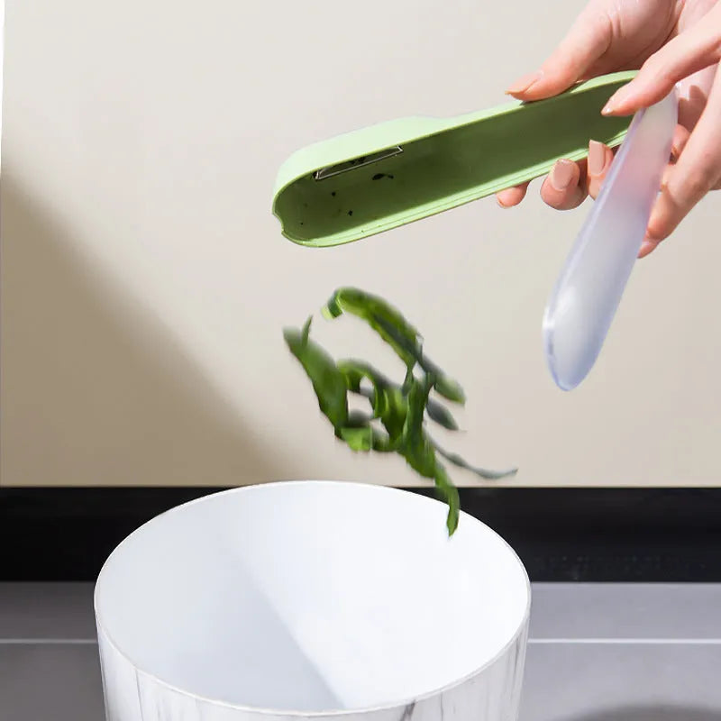 Dark green vegetable peeler with stainless steel blade and plastic storage tube