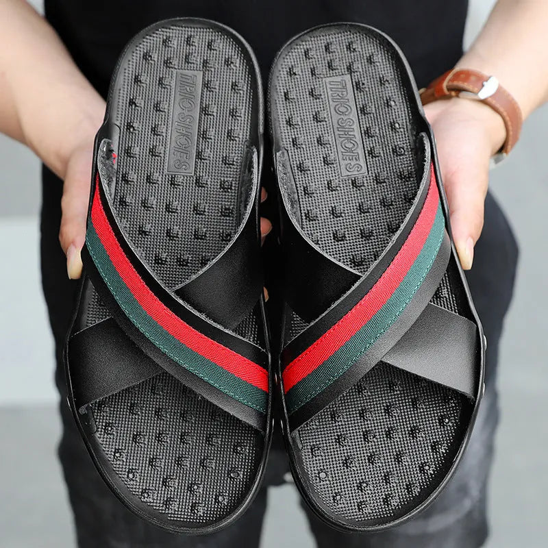 Men's cowhide leather flip-flop sandals with a non-slip PU sole in black, shown on a sandy beach.