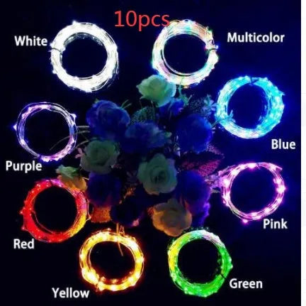 Silver wire LED string lights coiled around wine bottle with illuminated bulbs and bottle stopper fitting