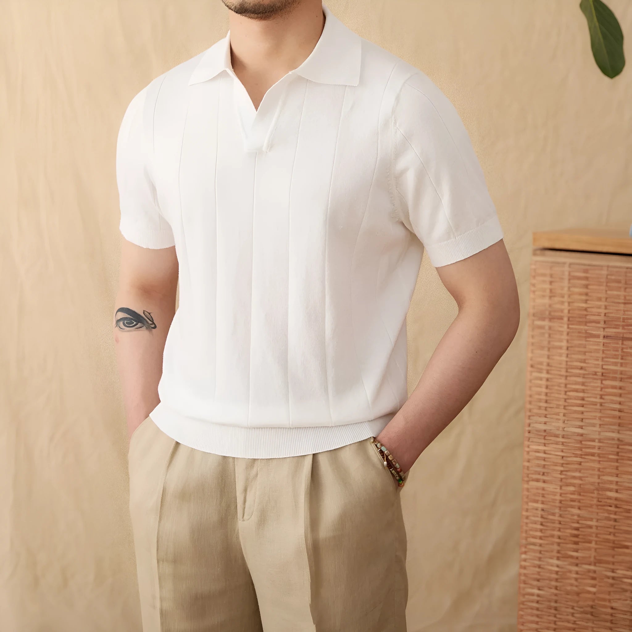 Man modelling a purple short sleeve polo shirt with a sunken stripe knit pattern and a seagull collar.