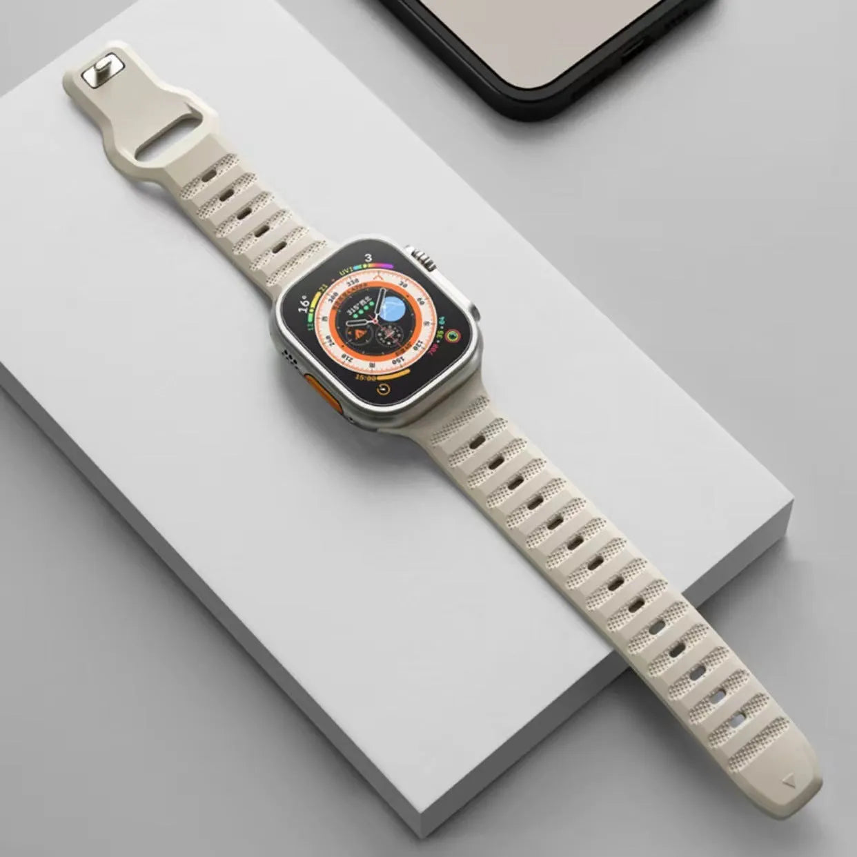 Fluoro rubber Apple Watch band with T-buckle in multiple colours on a grey background