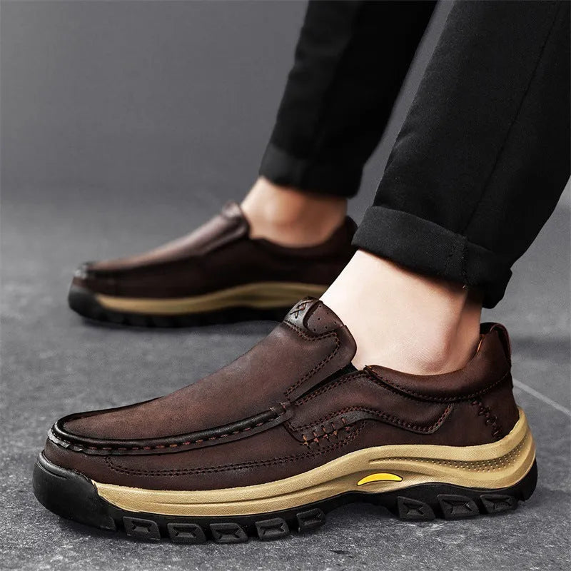 Men's black leather mountaineering shoes with thick rubber soles and round toe on a neutral background.