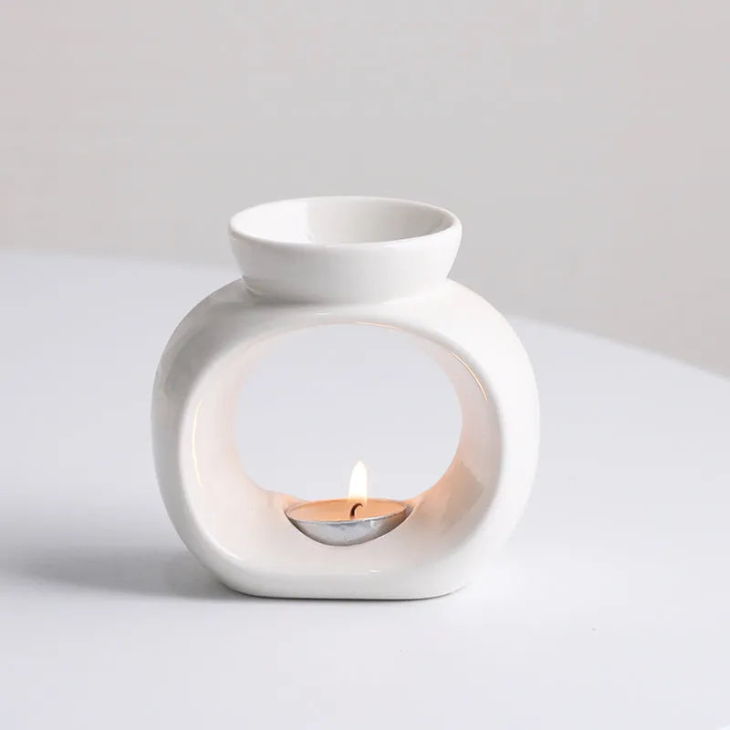 White ceramic Nordic-style aromatherapy stove ornament on a wooden surface.