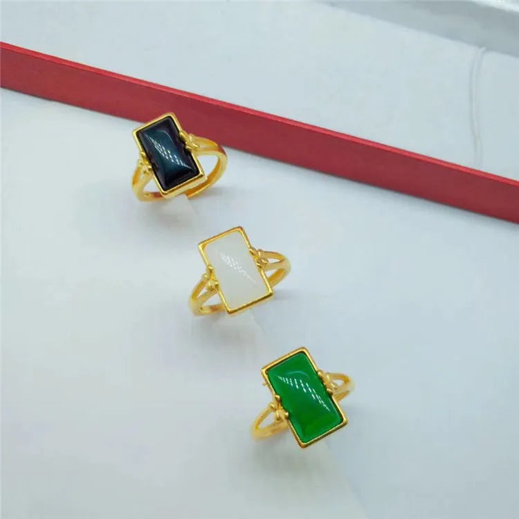Adjustable gold-plated brass ring with a long coloured gemstone in green, white, or black.