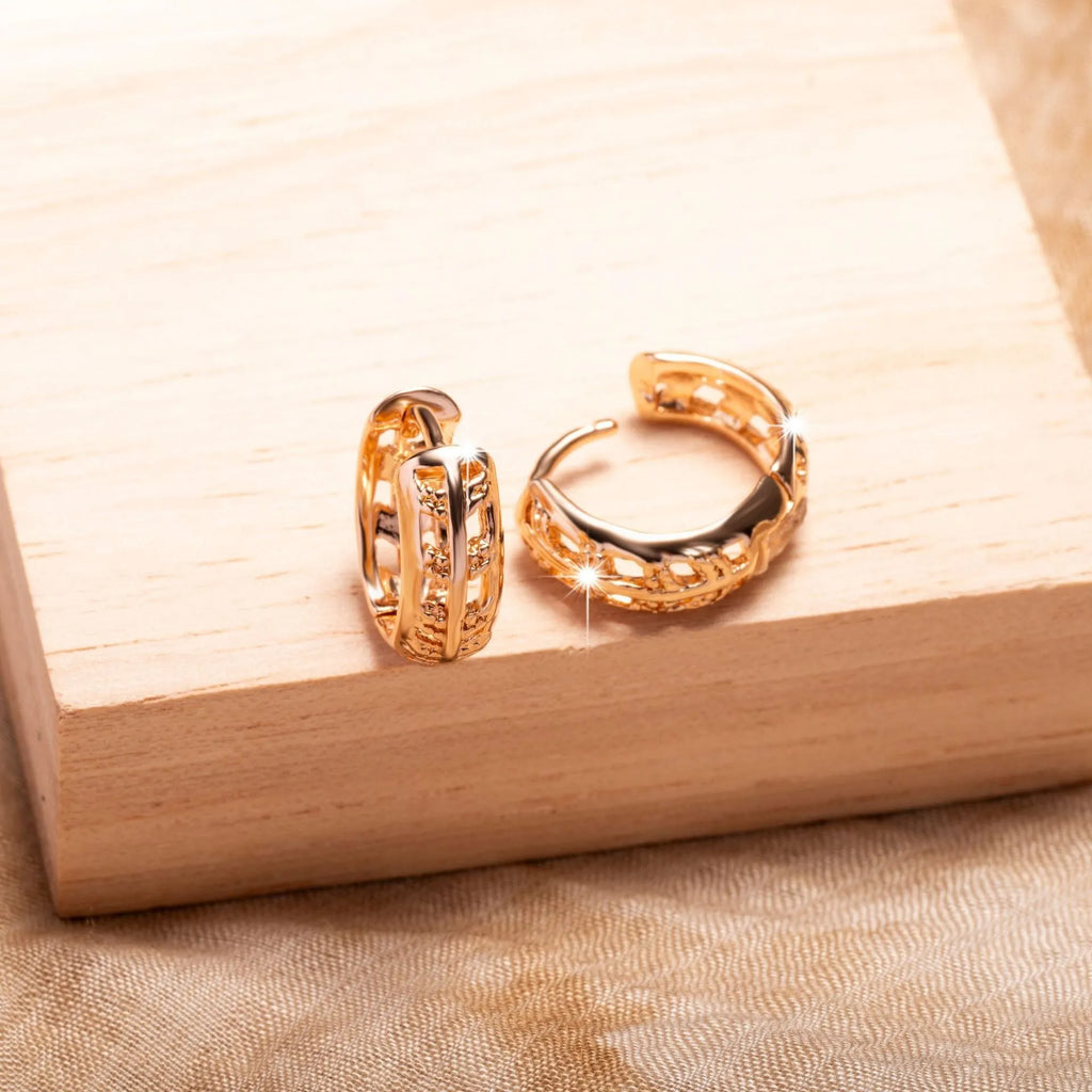 Small copper earrings with a hollowed-out heart-shaped leaf design in rose gold finish.