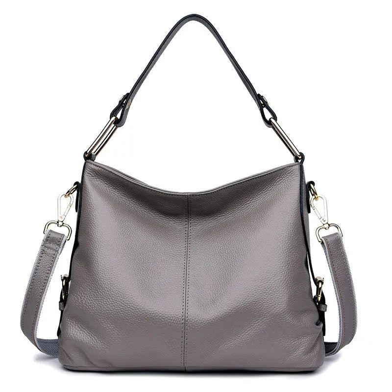 Square vertical genuine leather crossbody bag with multiple internal zipper compartments.