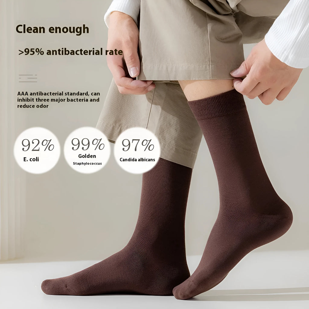 Men's solid colour pure cotton mid-calf business socks in beige, black, grey and blue shown folded.