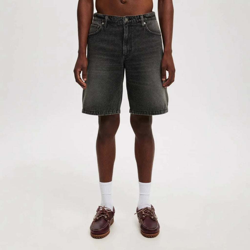 Men's light blue loose fit straight leg cotton denim jeans on a neutral background.