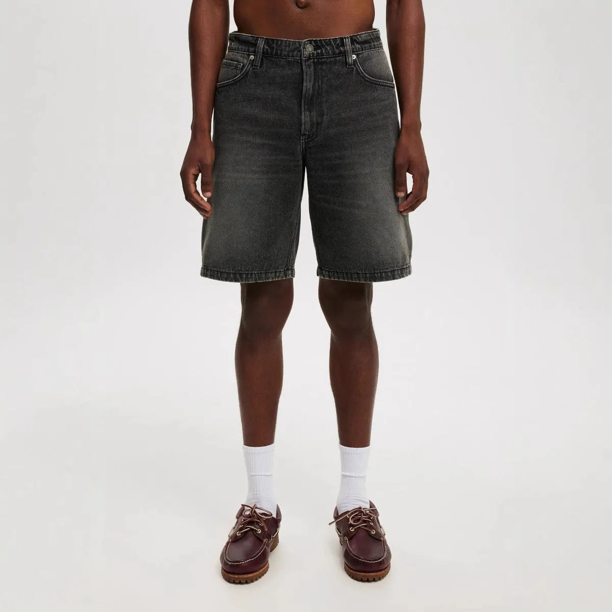 Men's light blue loose fit straight leg cotton denim jeans on a neutral background.
