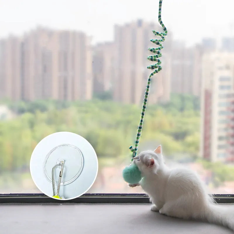 Colourful cat toy with spring bell stick and inflatable ball attached to a door by a suction cup