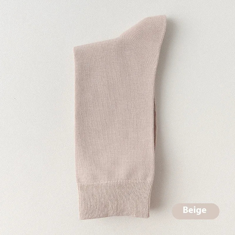 Men's solid colour pure cotton mid-calf business socks in beige, black, grey and blue shown folded.
