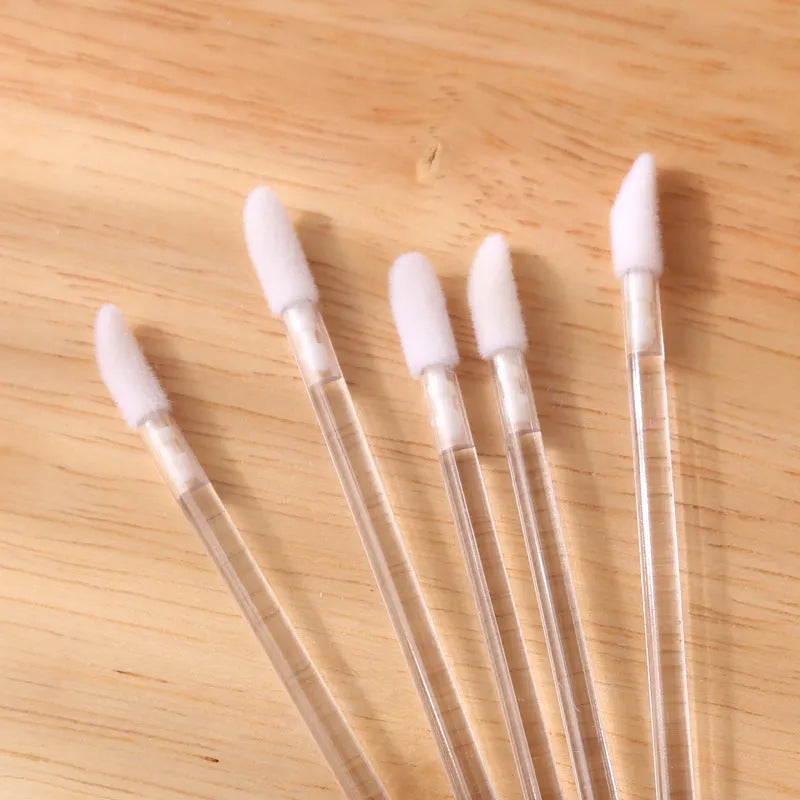 Disposable lip brush applicators with flocked heads in multiple handle colours on white background