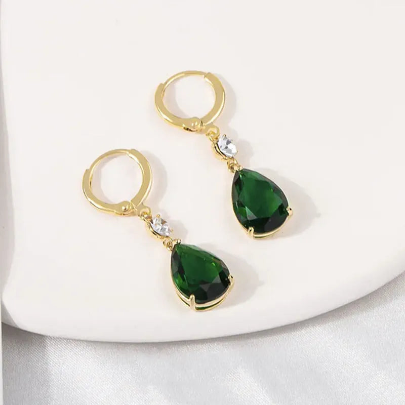 A pair of green geometric teardrop-shaped alloy earrings on a white background.