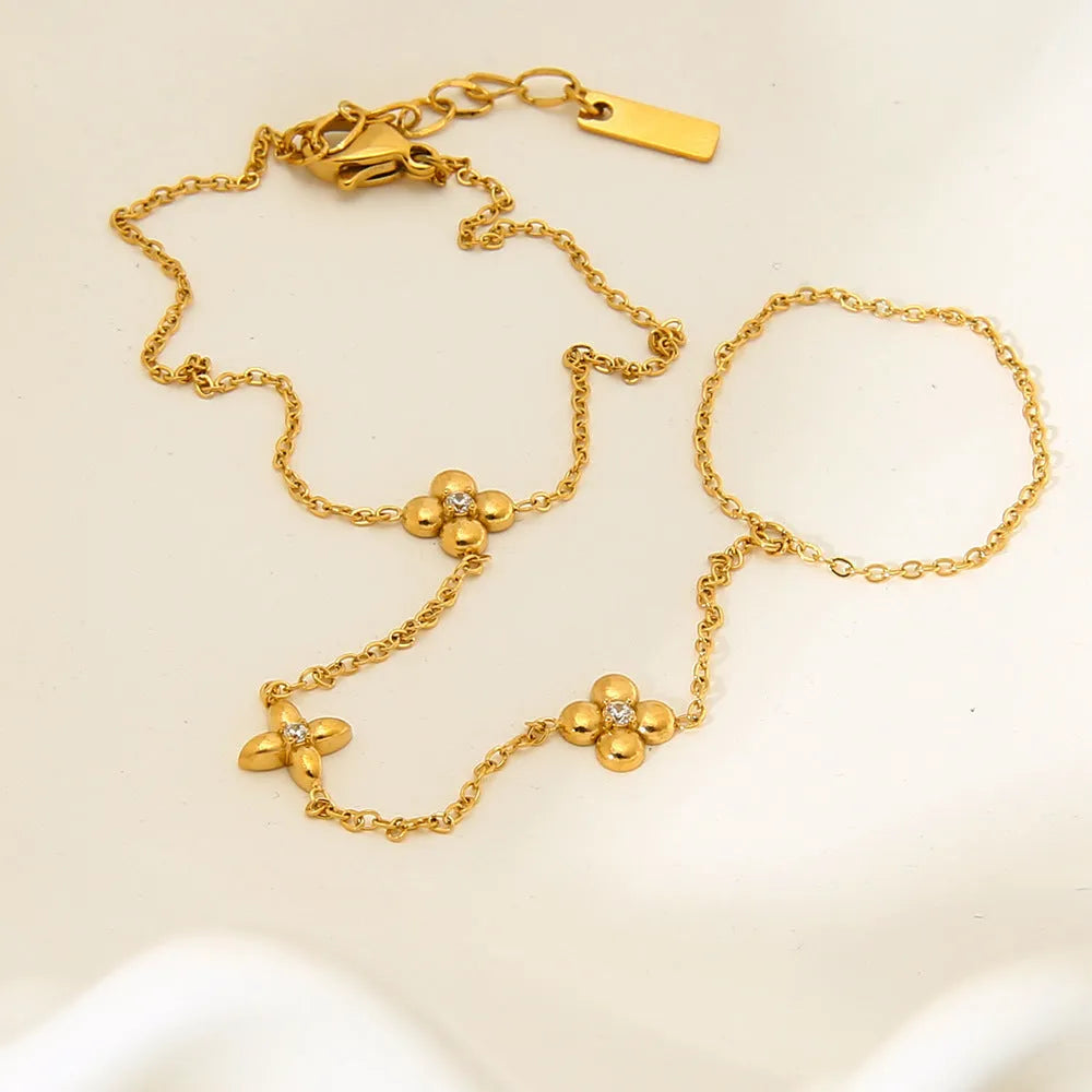 Gold stainless steel women's bracelet with geometric shape, flower and eight-pointed star details.