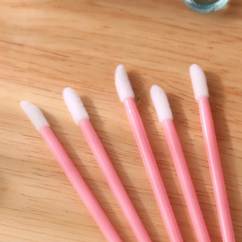 Disposable lip brush applicators with flocked heads in multiple handle colours on white background