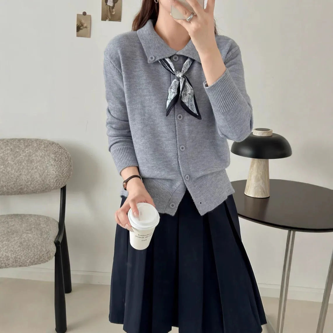 Women's beige lapel scarf collar acrylic cardigan sweater on a hanger.
