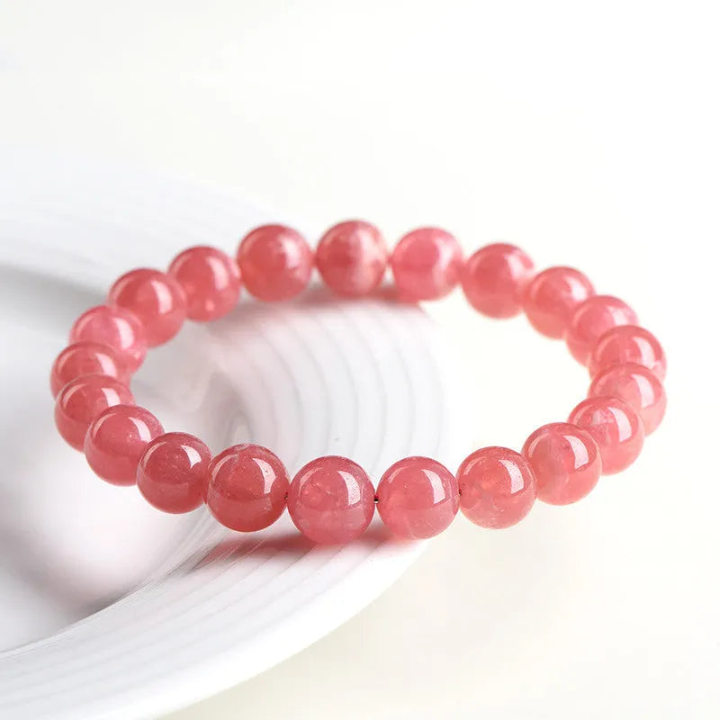 Women's red rhodochrosite crystal bracelet with geometric pattern and longevity lock clasp showing natural stone variations