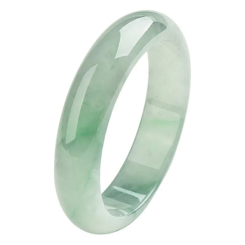 Light green polished jade bracelet in a natural style on a wrist.