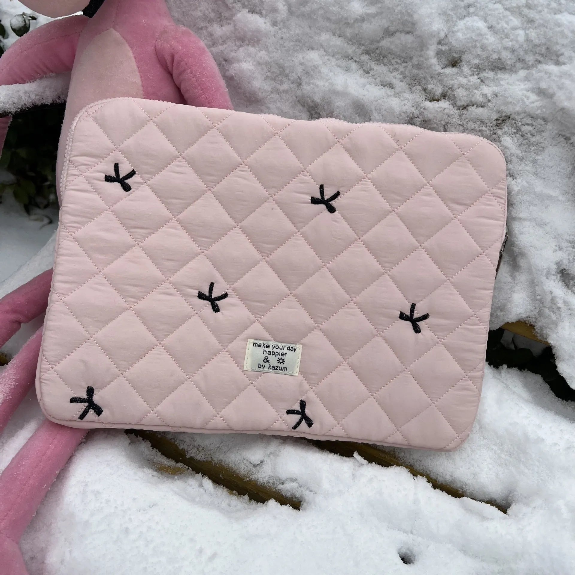 Cute white nylon laptop bag with a rhombus embroidered bow, shown next to a laptop.