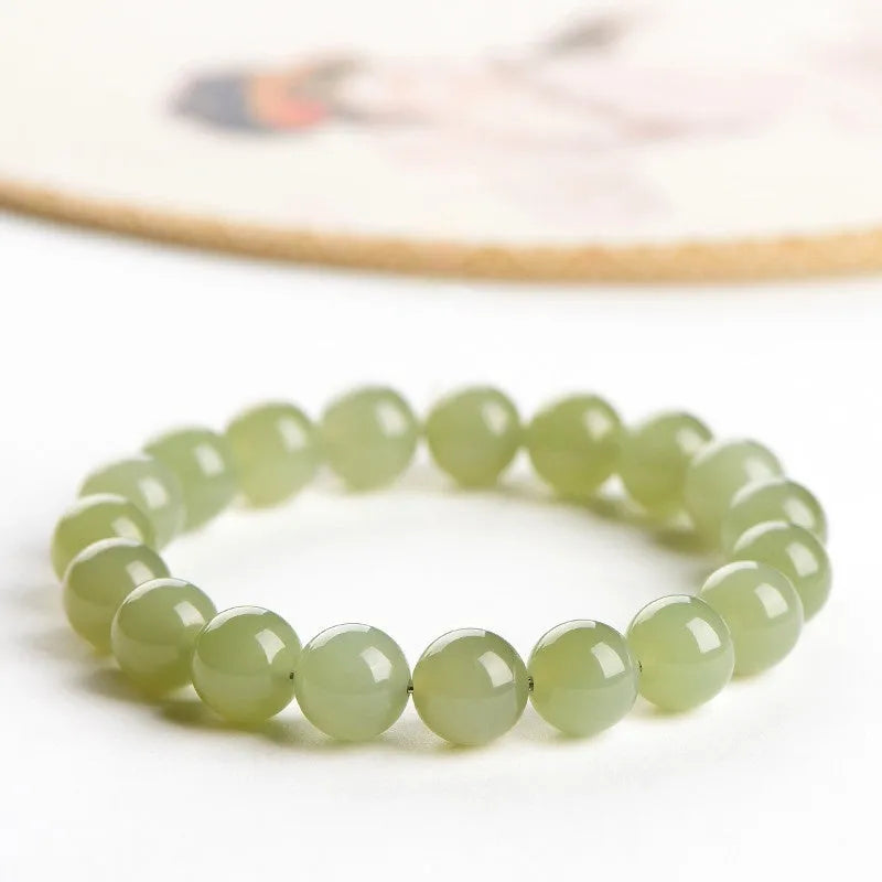 A polished Hetian jade bead bracelet in a light ice-clear colour, showing smooth round beads on a string.