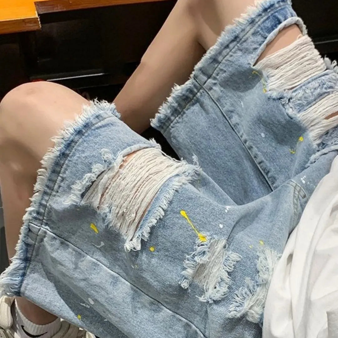 Men's loose-fit denim shorts with water-washed finish and hole detailing in light blue.