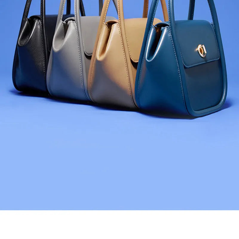 Soft cow leather wing-shaped tote handbag with a buckle and cross-body strap in four colour options.