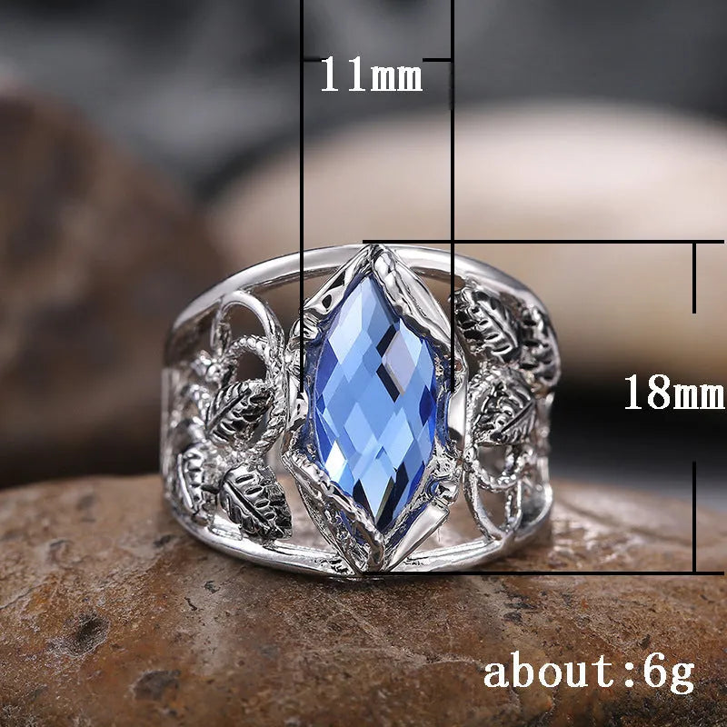 Close-up of a women's horse eye shaped blue crystal ring on a finger.