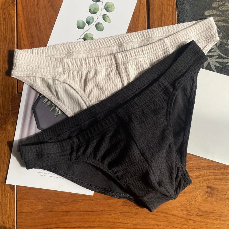 Men's solid colour cotton briefs with mid waist and triangle style in apricot black and skin colour.