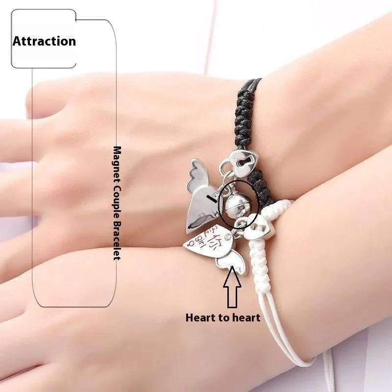 Pair of magnet couple bracelets with suction clasp on wrist, showing alloy designs like crown and love lock.