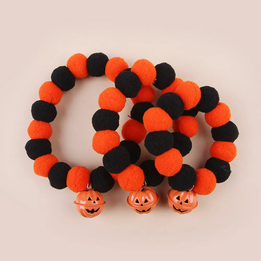 Orange Halloween cat collar with black pumpkin print and a silver bell, shown with an adjustable buckle.
