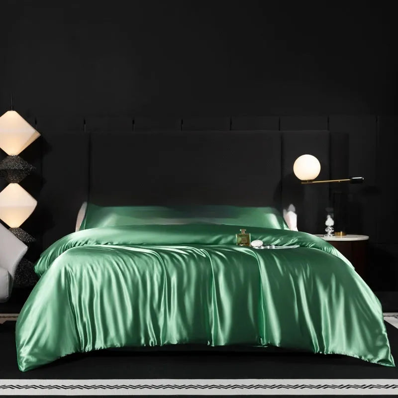 Solid colour silk bedding four-piece set shown in twilight blue on a bed.