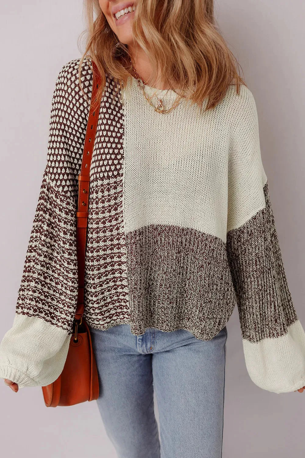 Dark khaki colour block loose sweater with back tie and drop shoulders on a hanger.