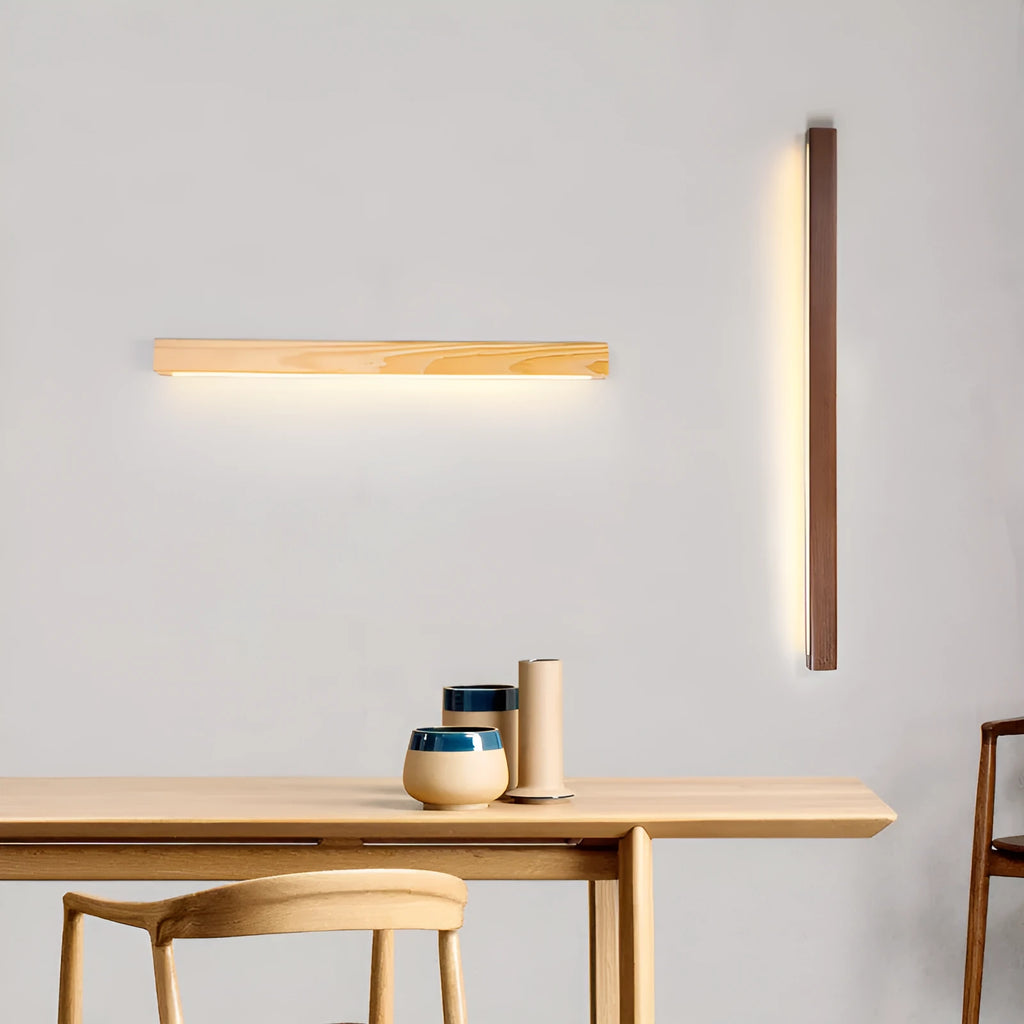 Walnut coloured log strip wall lamp with a square wood and acrylic profile mounted on a wall.