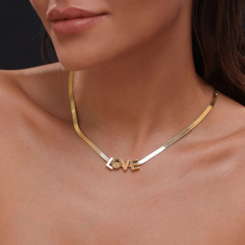 Gold and silver titanium steel necklaces showing letter A and number 7 pendants on 40.5cm chains.