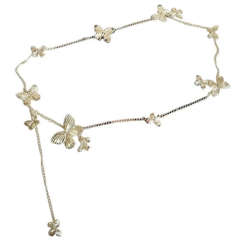 Gold and silver butterfly motif waist chain jewellery belt for women on a plain background.