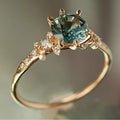 Gold coloured geometric ring with claw setting and square patterned band.