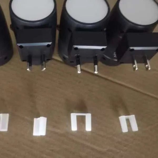 Small white induction night lamp with a direct plug, adjustable dial, and rotatable light head.
